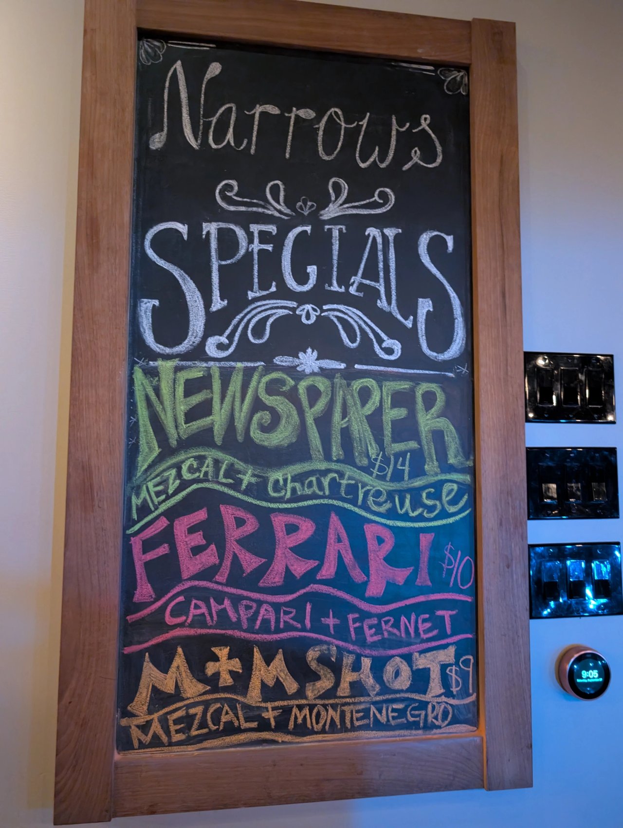 A chalkboard at The Narrows listing Newspaper, Ferrari and M and M Shot specials