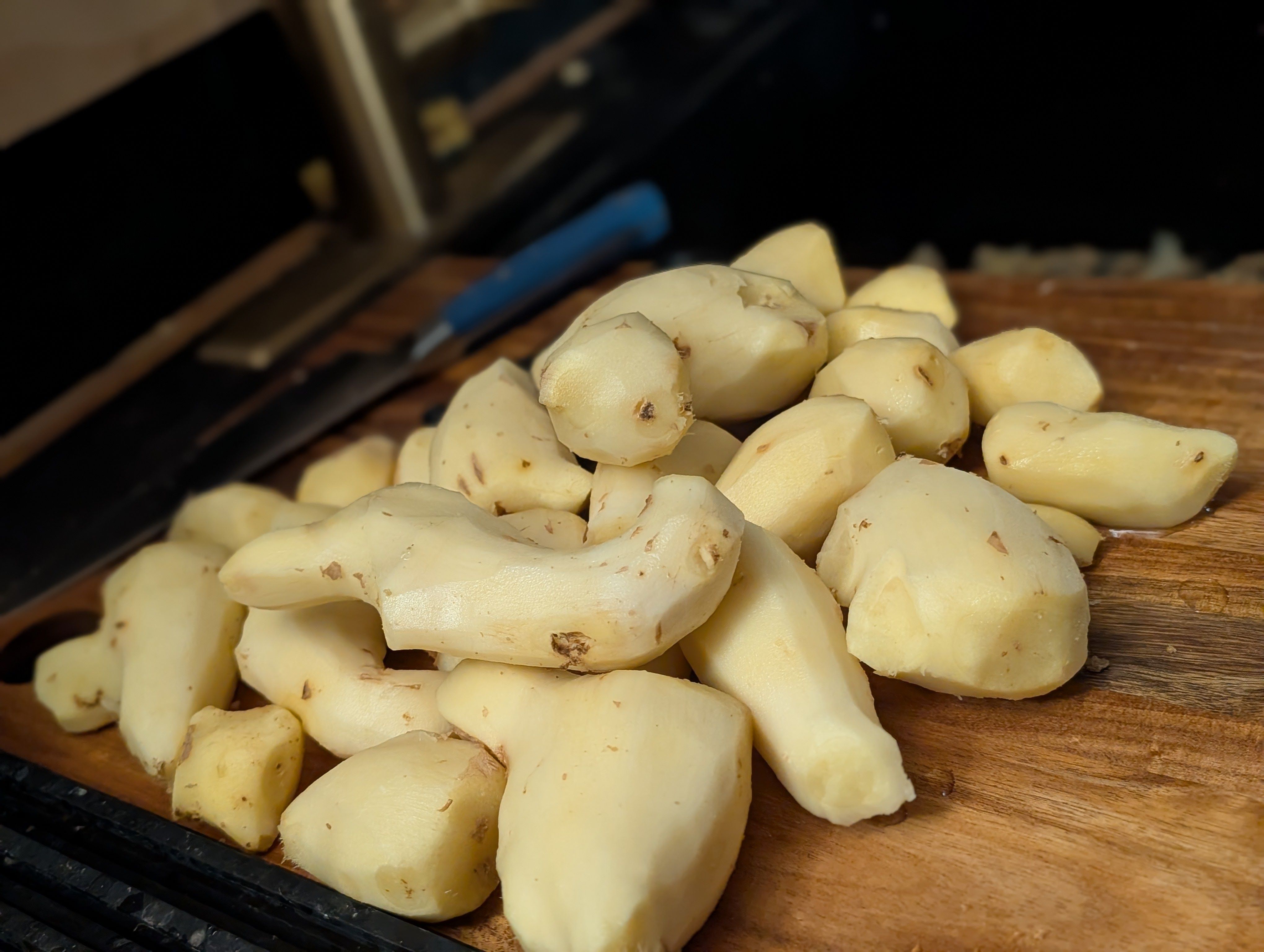 Peeled fresh ginger pieces on a wooden cutting board.