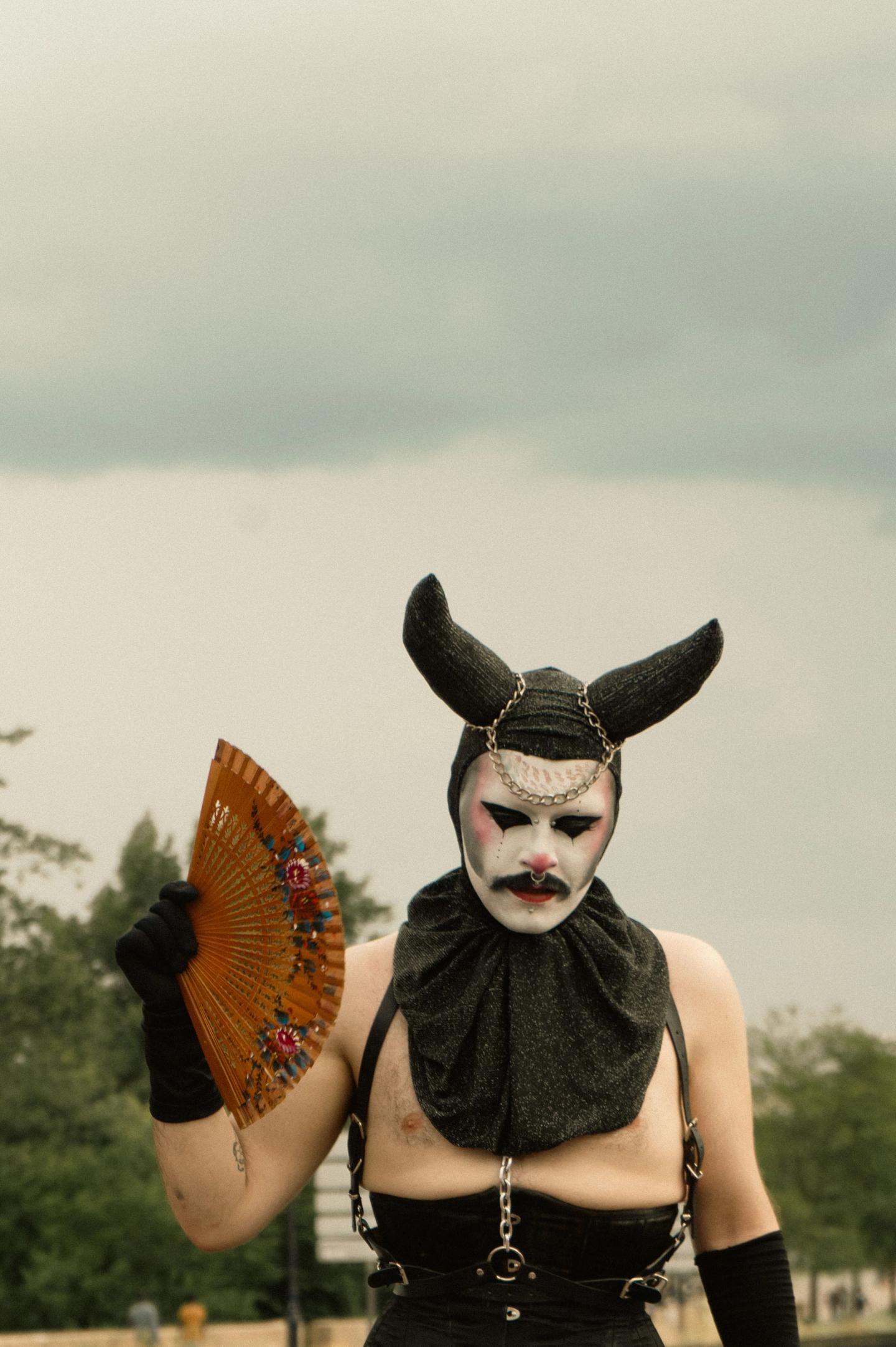 A drag queen with horns and a fan