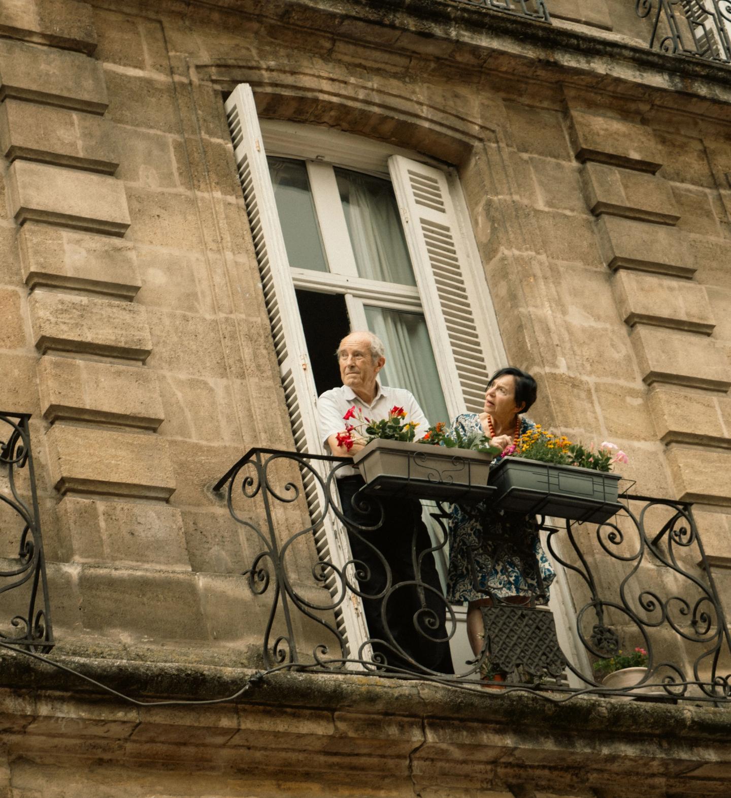 An elderly couple on their balcony on Pride day.