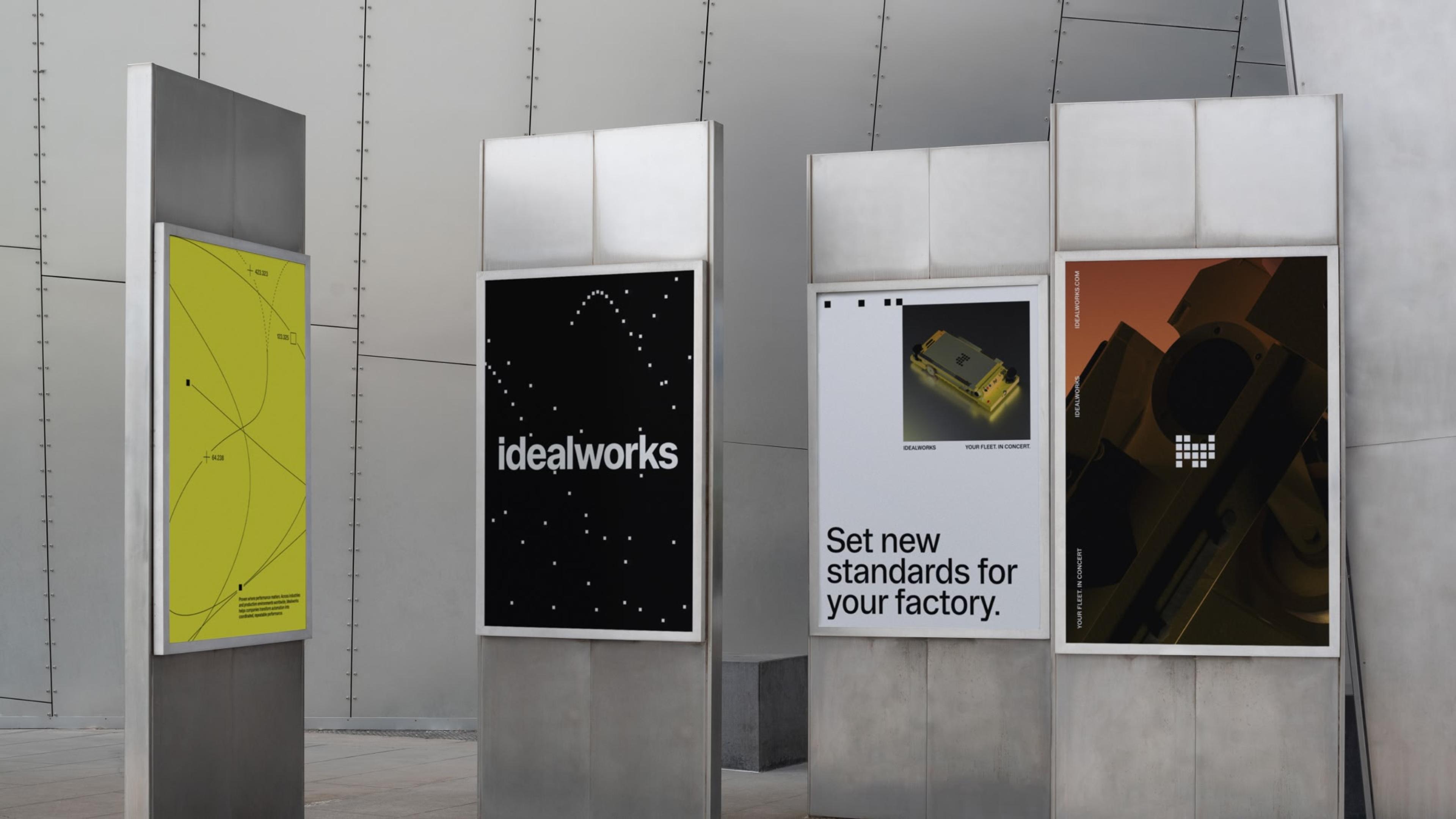 Various Idealworks posters in an industrial outdoor setting