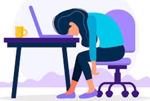 Bilde av en utmattet person sittende ved skrivepult