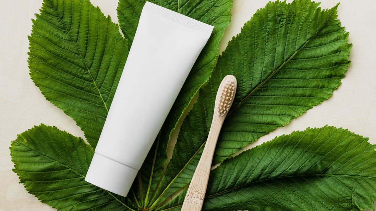 Bilde av tannbørste og tannpasta på et grønt blad