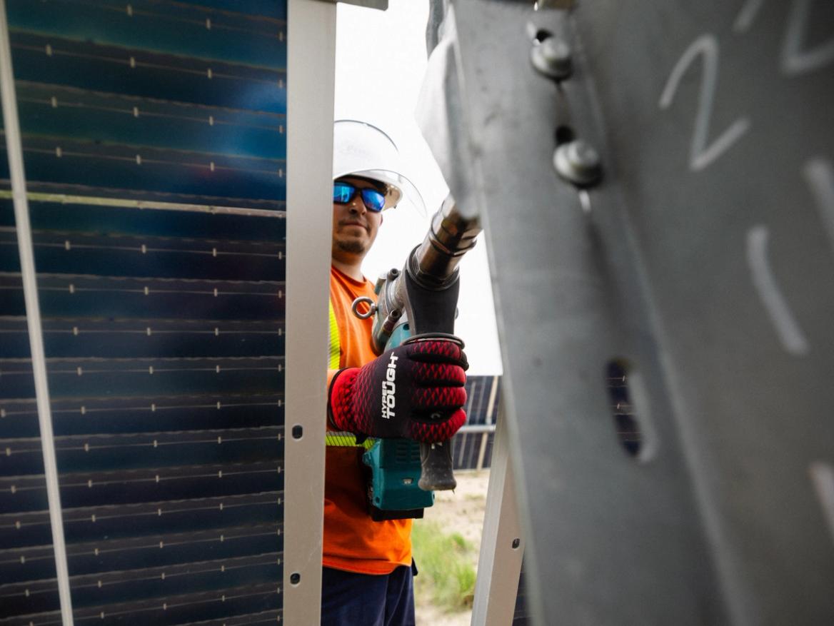 Two solar construction crew members reviewing the field at sunrise
