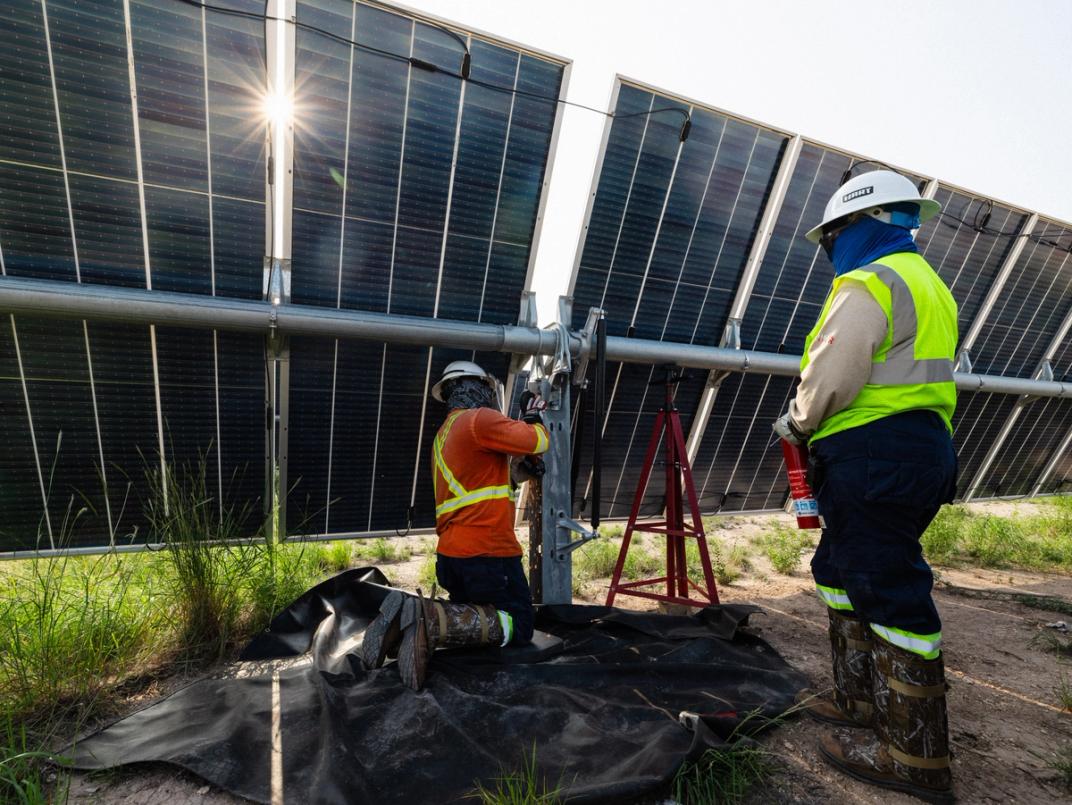 Solar maintenance crew performing repairs on a solar tracker