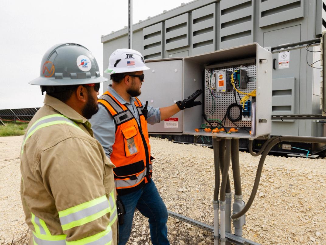 Solar electrical worker performing final terminations at sunset
