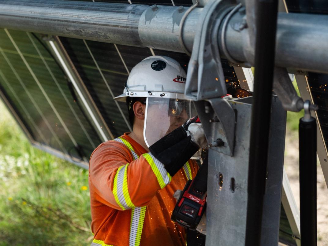 Solar installer mounting modules on a tracker