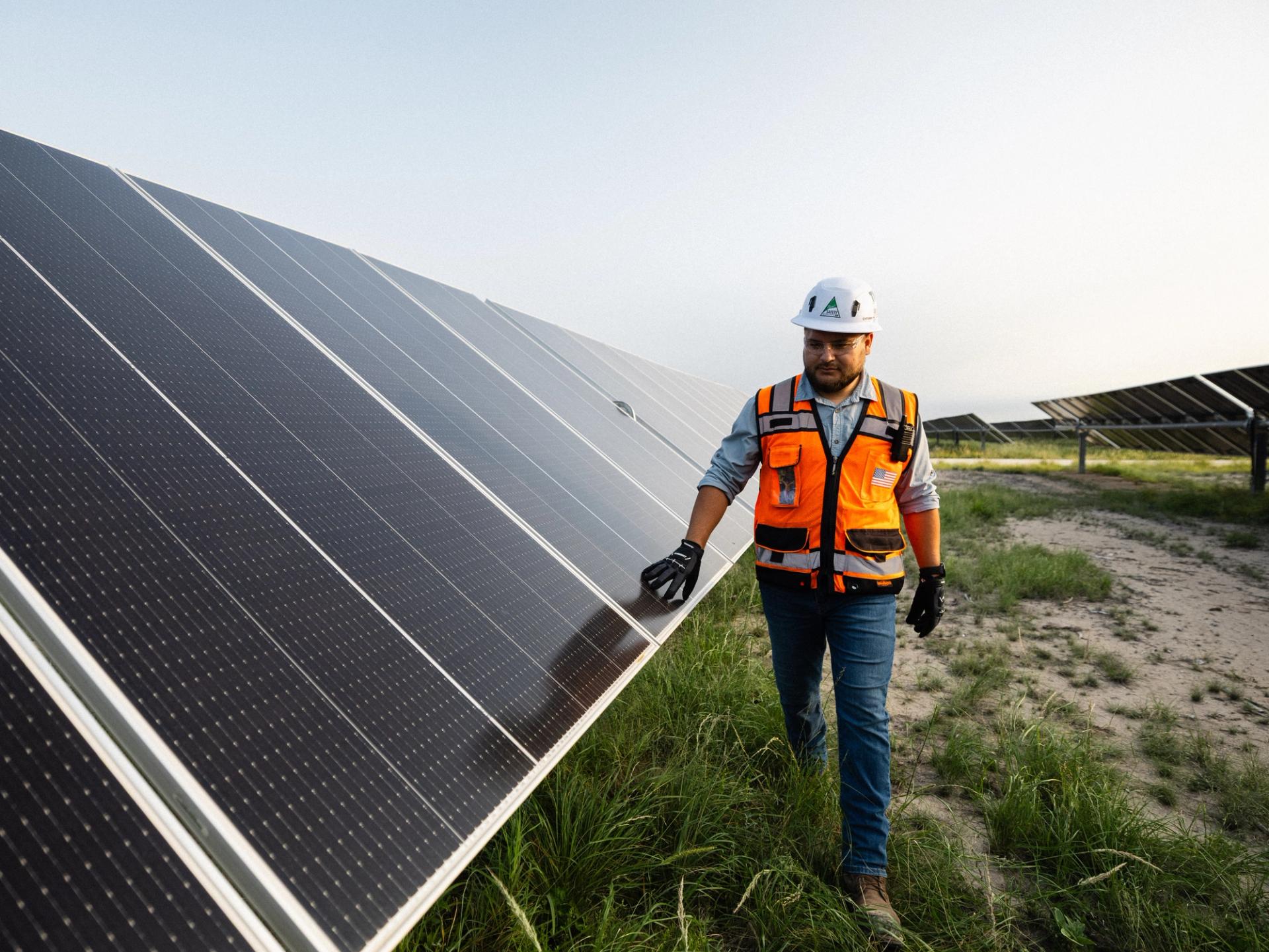Power Ray crew member on a utility-scale solar construction site at sunset