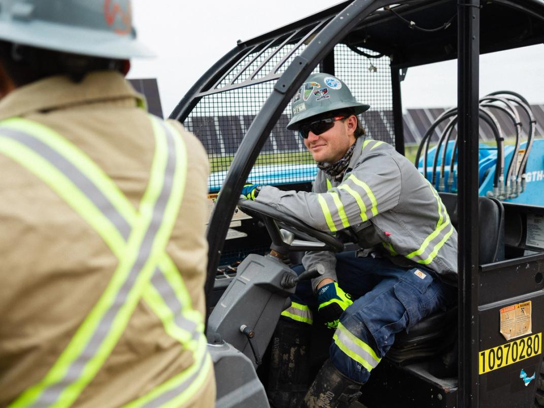 Solar installer wearing safety gear on a job site