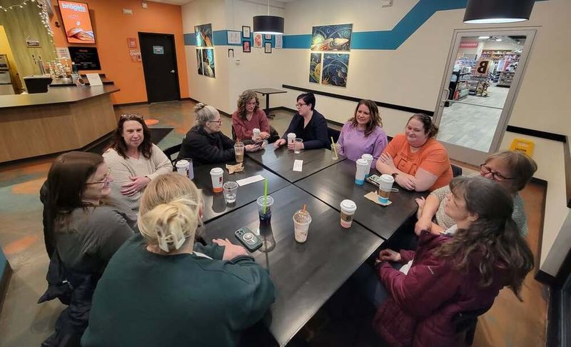 A group of adults talking around a table over coffee