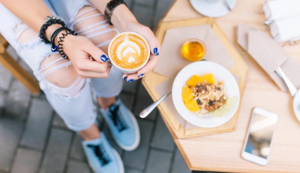 Kvinne spiser frokost ute