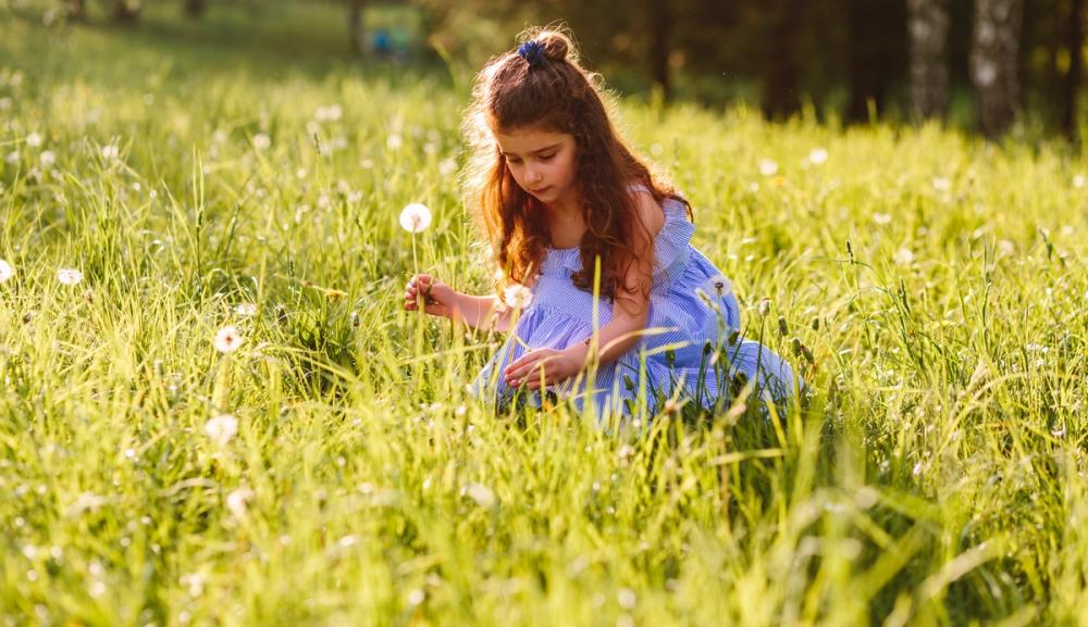 Ung jente plukker blomster