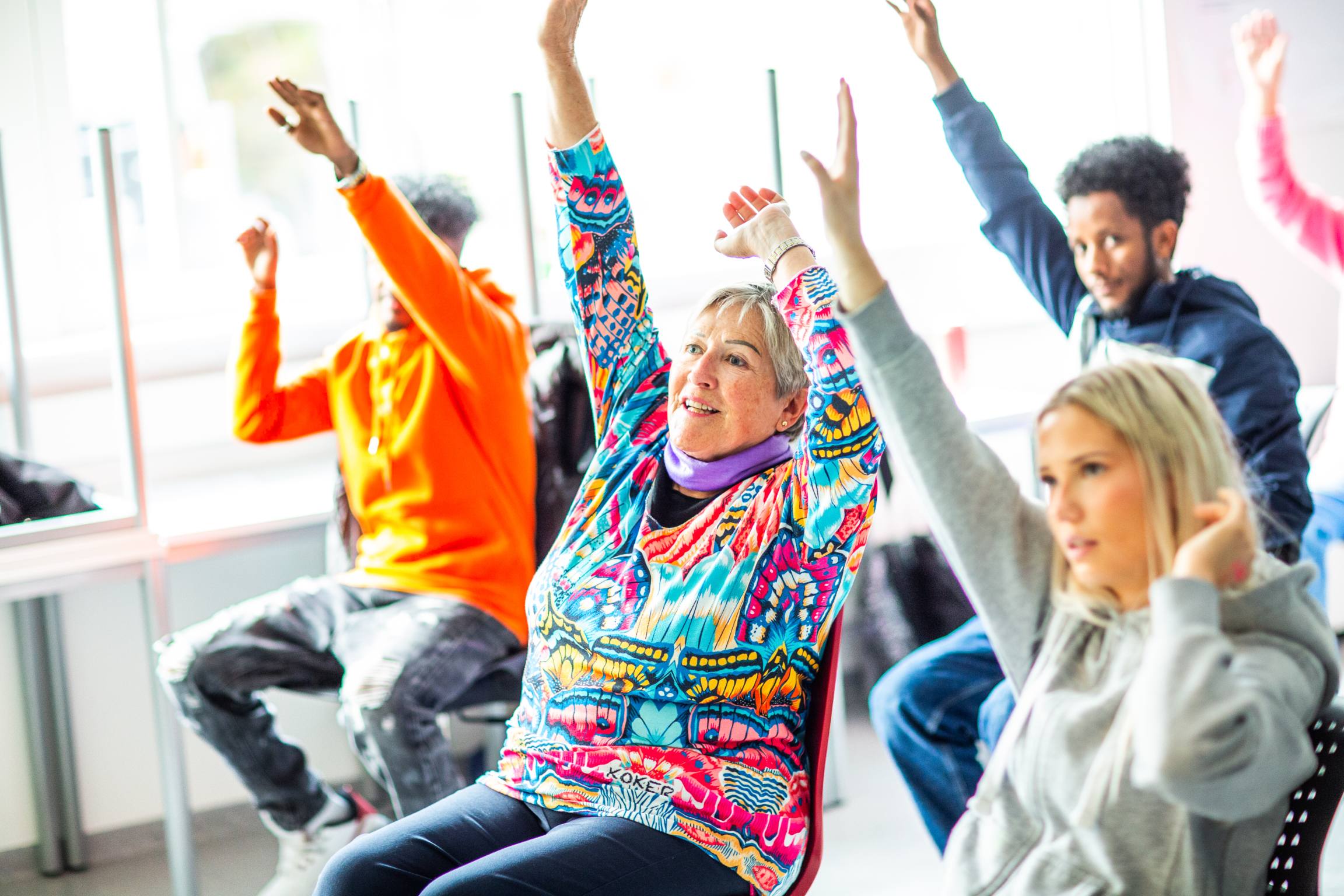 Sangstund for Helse- og omsorgsarbeiderfag, elever og eldre synger og trimmer sammen