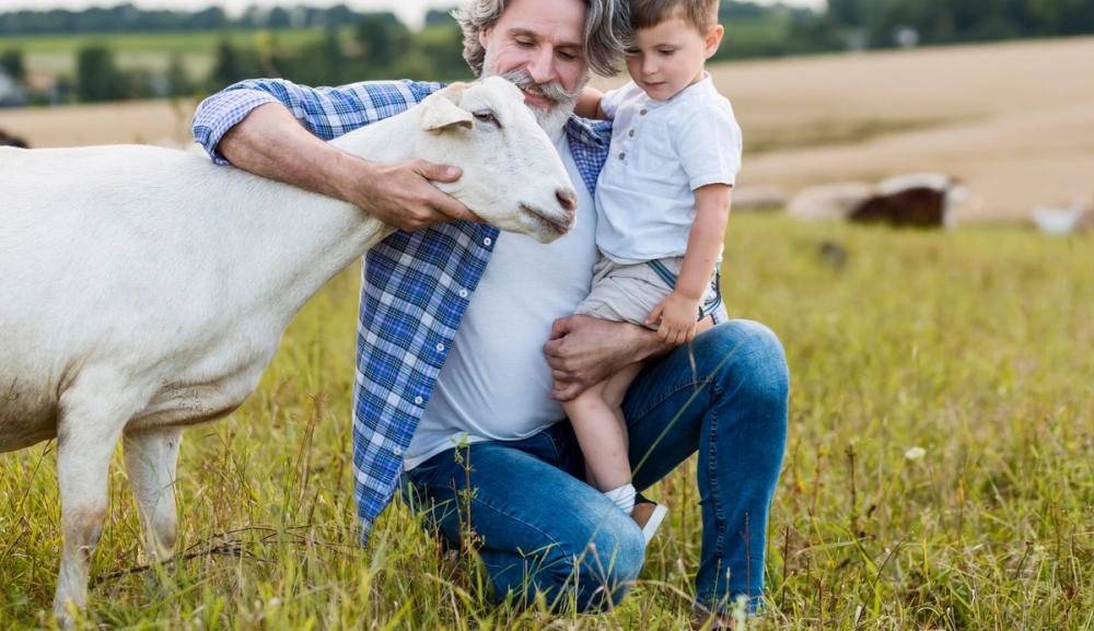 Mann og ung gutt koser med bukk