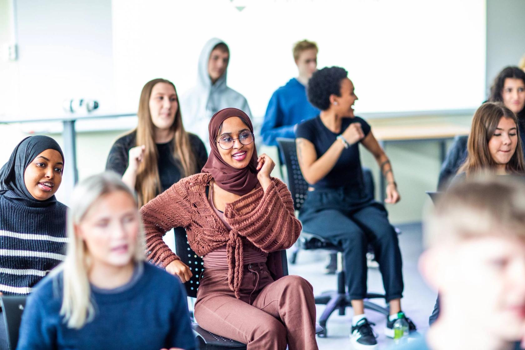 En ung VGS-elev danser og ler sammen med en voksen kvinne og en eldre mann på en syngende institusjon