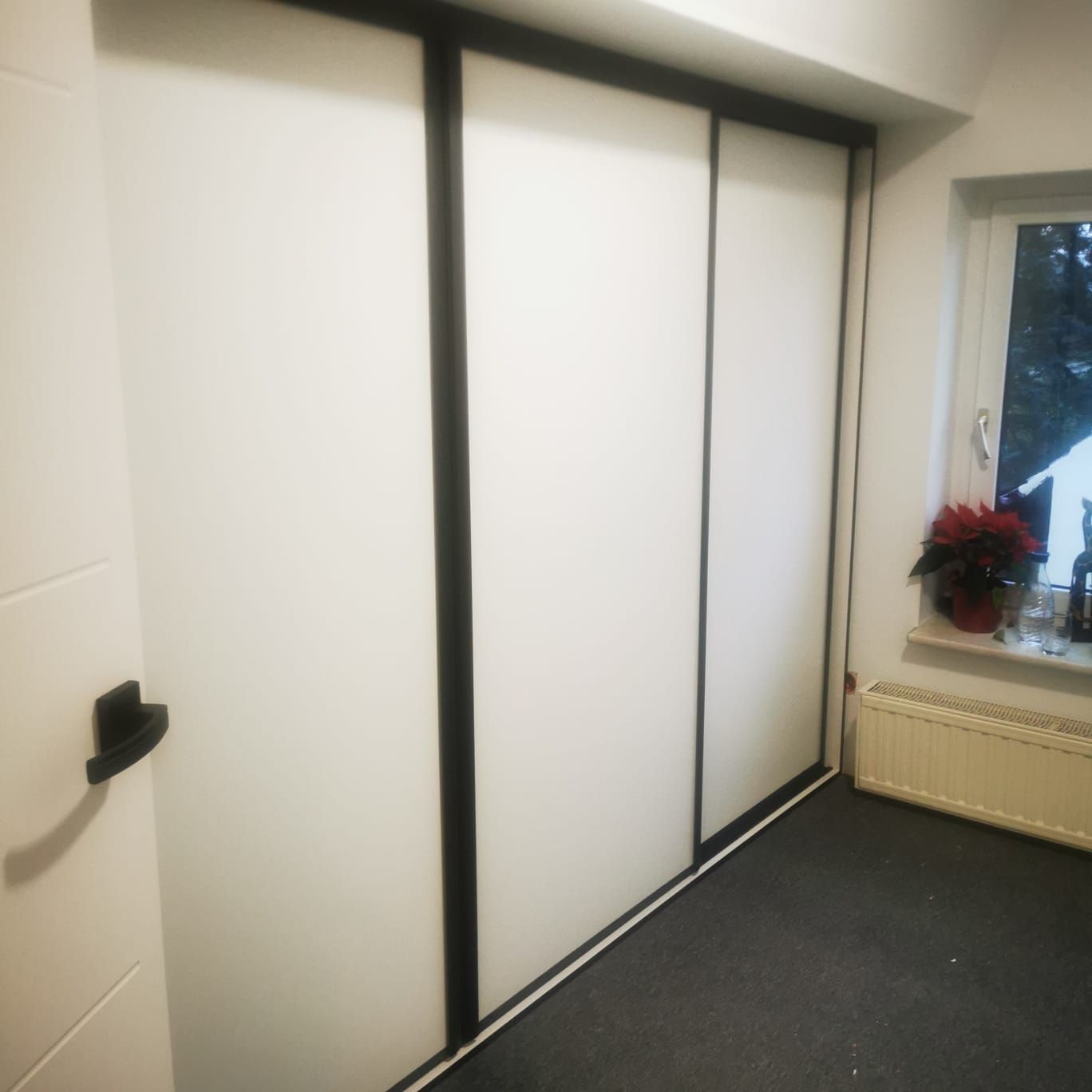 Szafa przesuwna biała w czarnej aluminiowej ramie pod skos poddasza