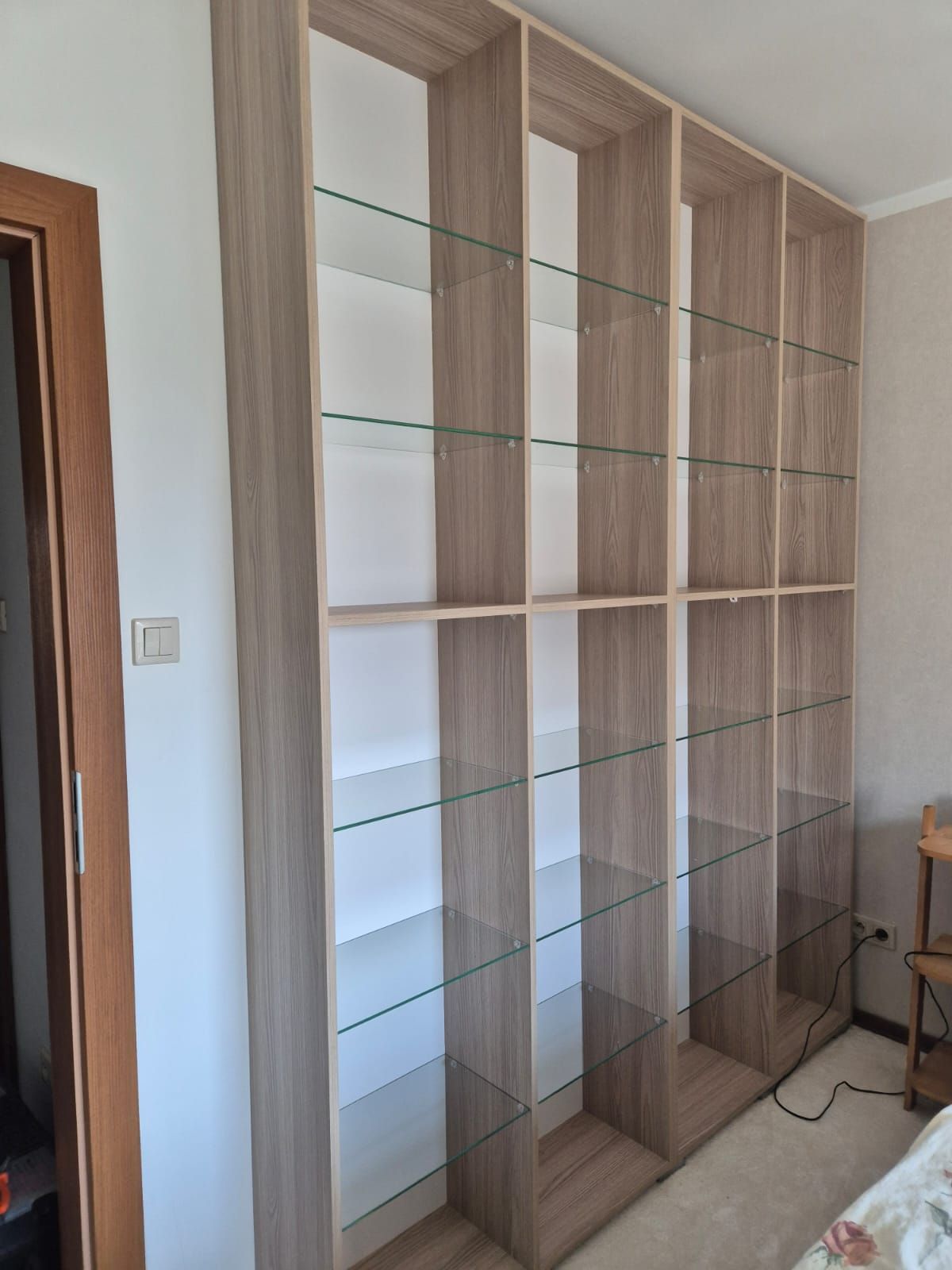 Wysoki regał biblioteczny z półkami szklanymi, korpus w dekorze dębu trufla
