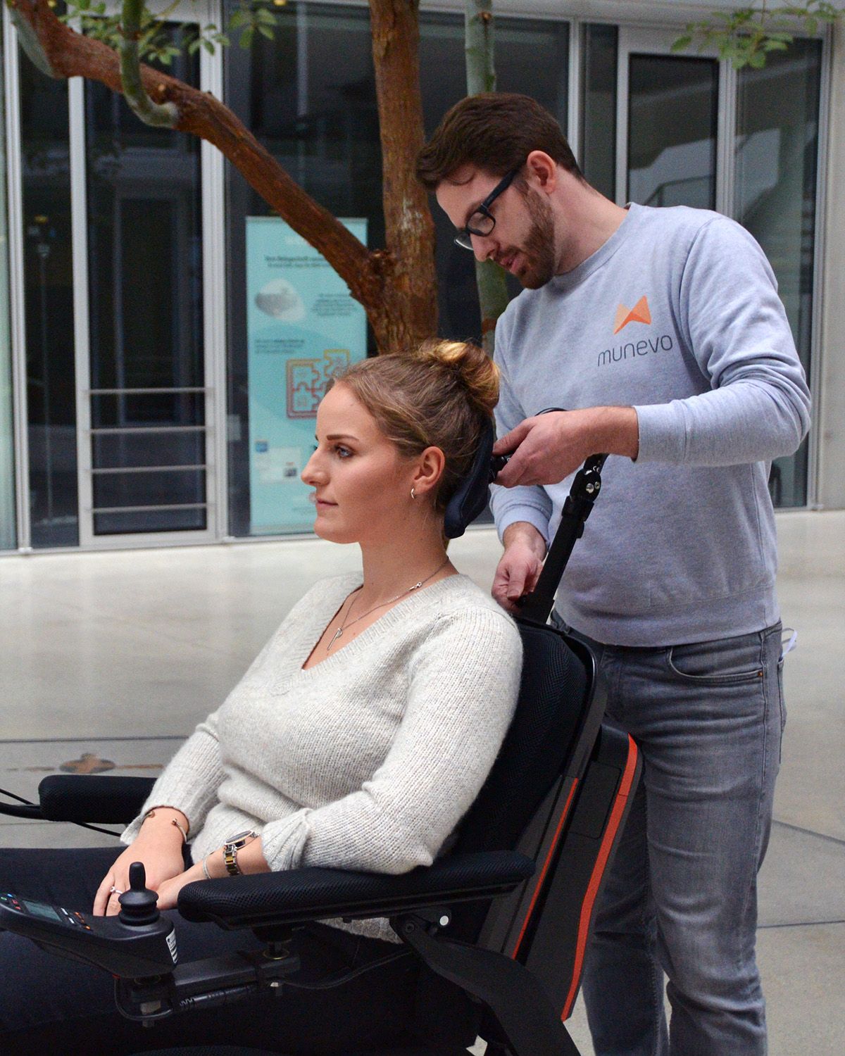 munevo employee setting up munevo DRIVE for a user. The employee is adjusting the user's headrest.