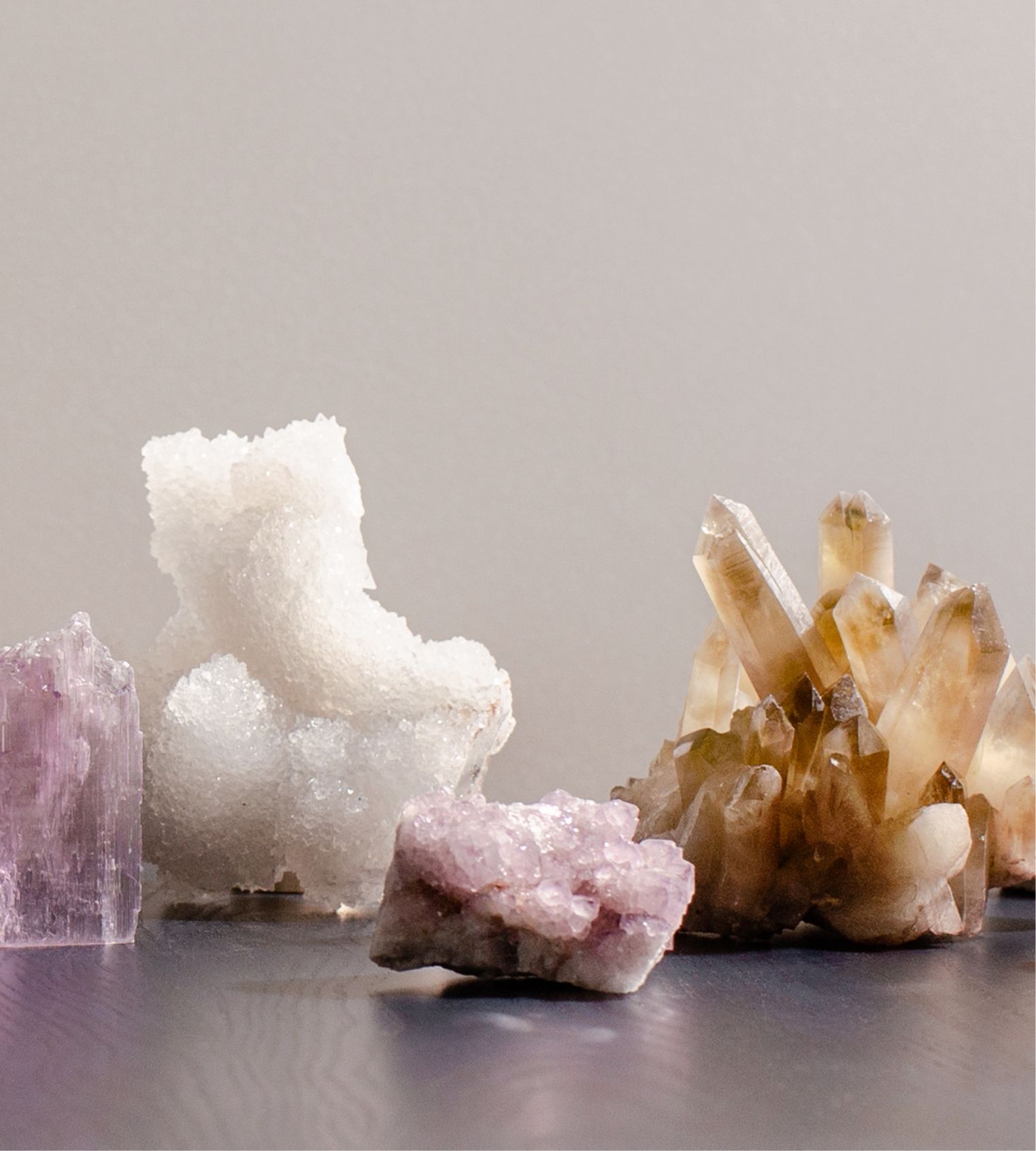The New Moon’s Guide to Cleansing and Choosing crystals, still life photography by Amanda Kho of colourful crystals lined up on a table