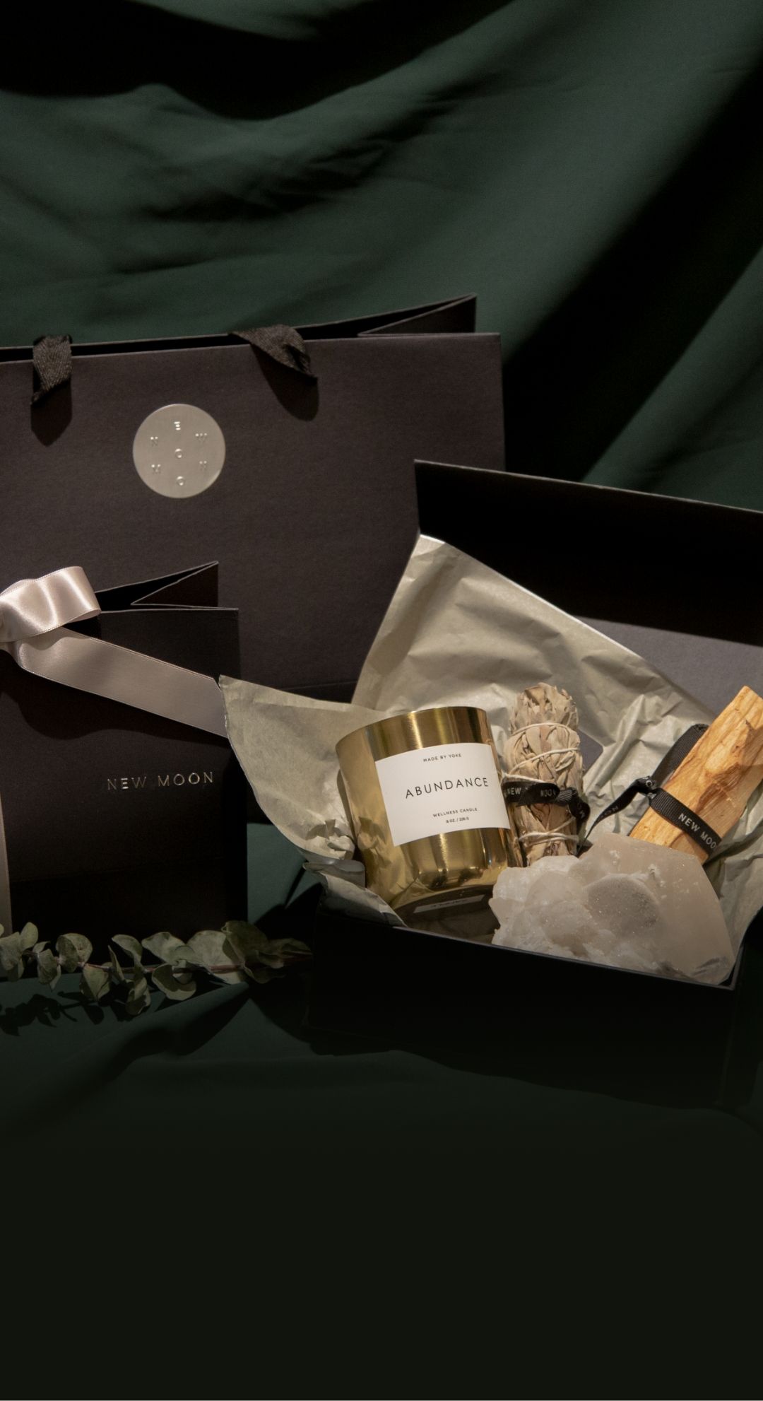 The New Moon Christmas gift packaging against dark green back drop