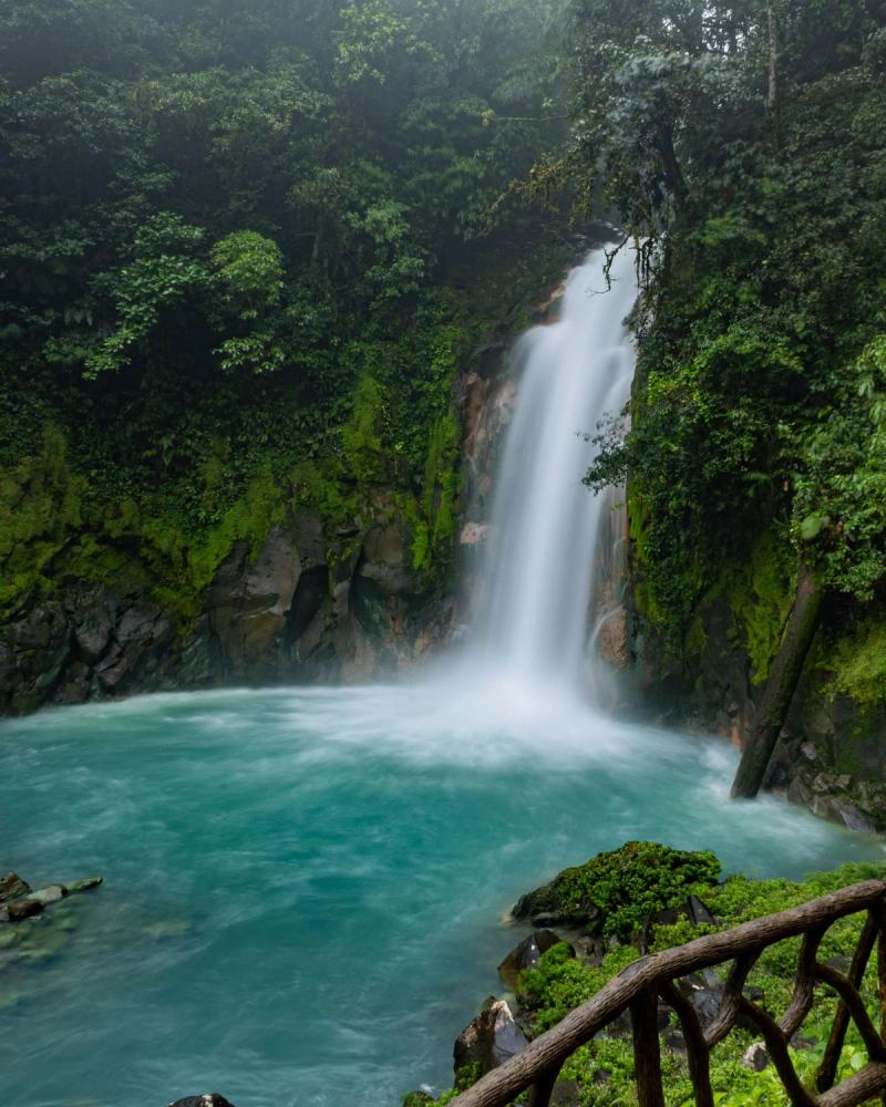 Cascada de Río Celeste rodeada de bosque tropical y agua turquesa