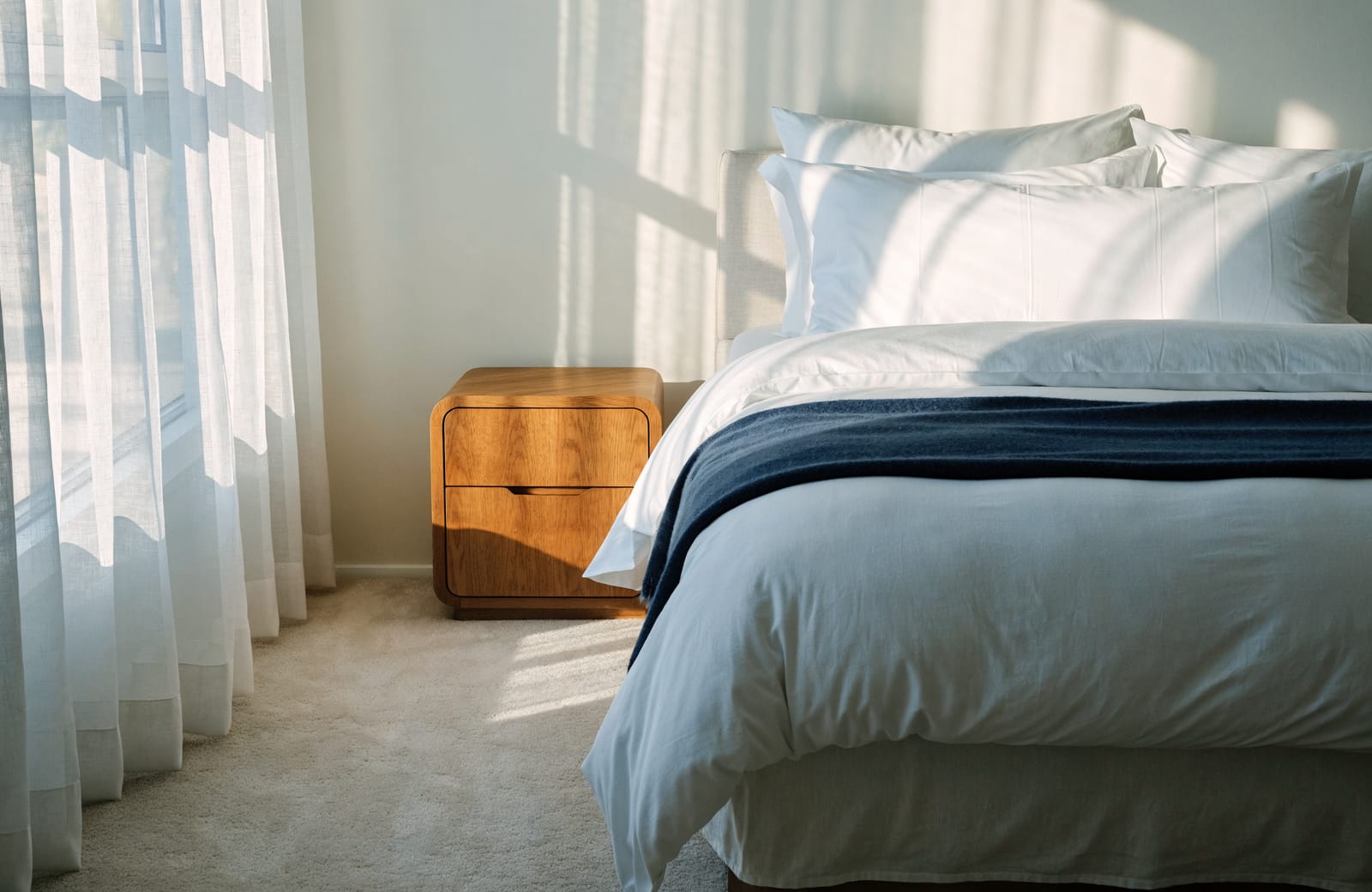 A bright bedroom with a freshly made bed