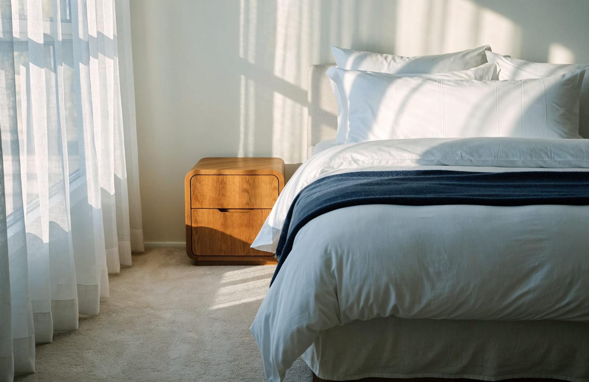 A bright bedroom with a freshly made bed