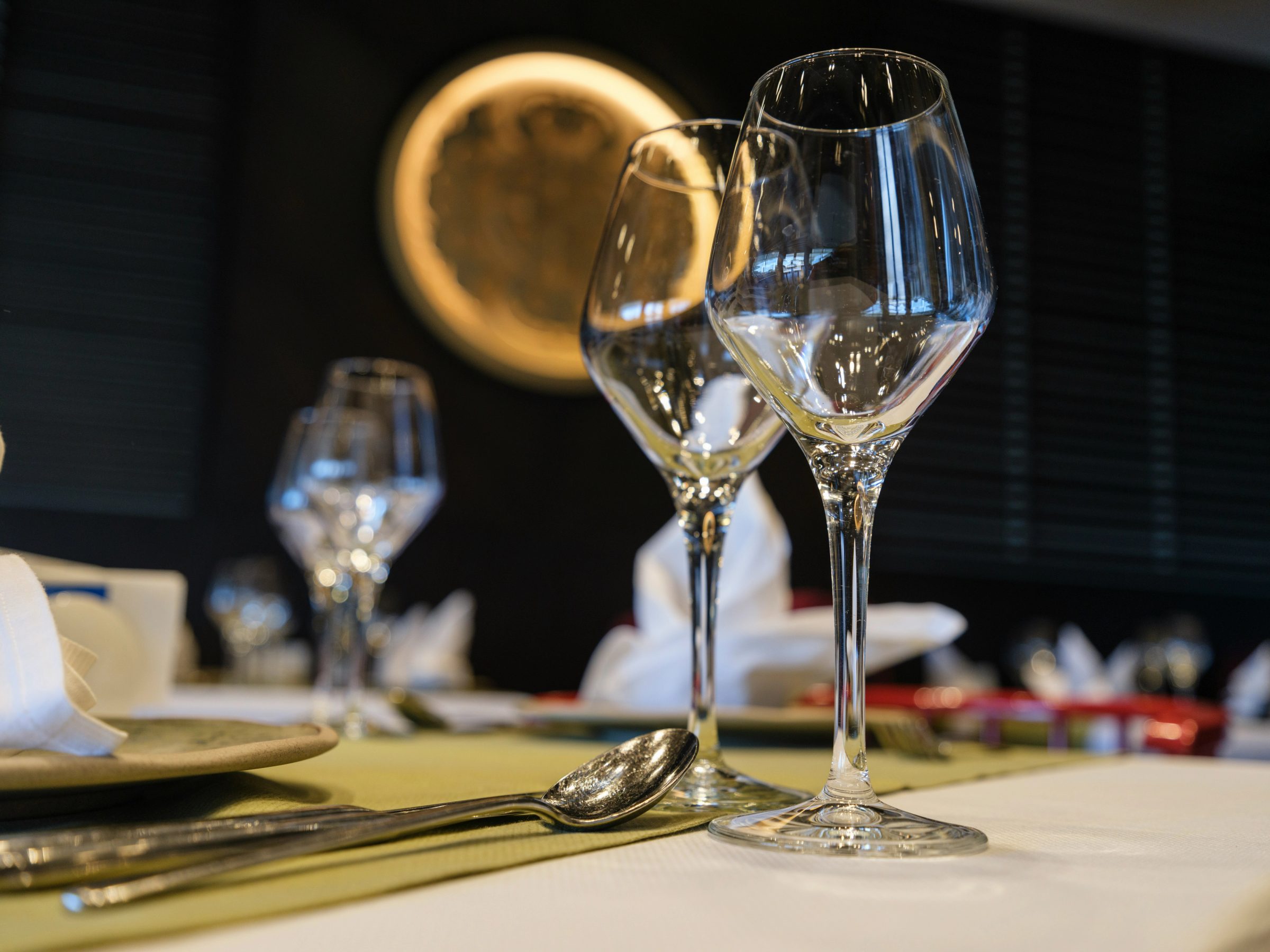 Set table with wine glasses, cutlery and napkin against dark background