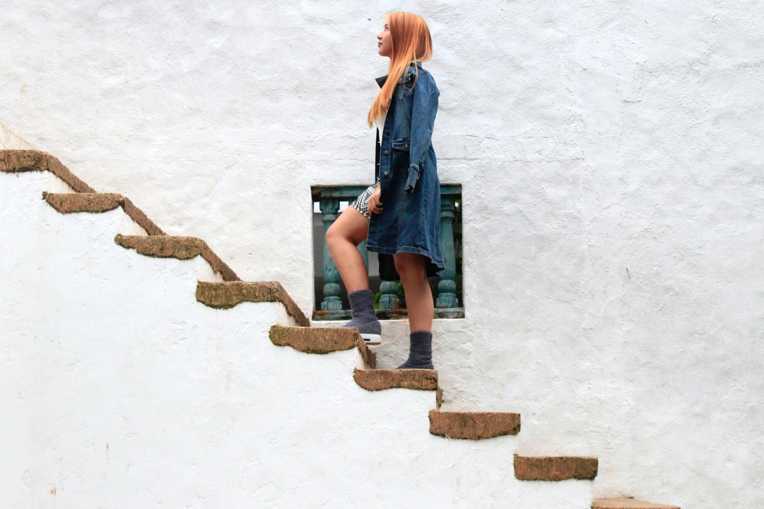 Woman ascending a staircase, symbolizing increased settlement amounts through client participation in personal injury cases