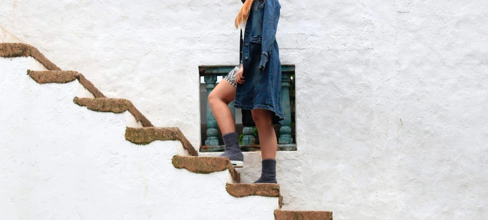 Woman ascending a staircase, symbolizing increased settlement amounts through client participation