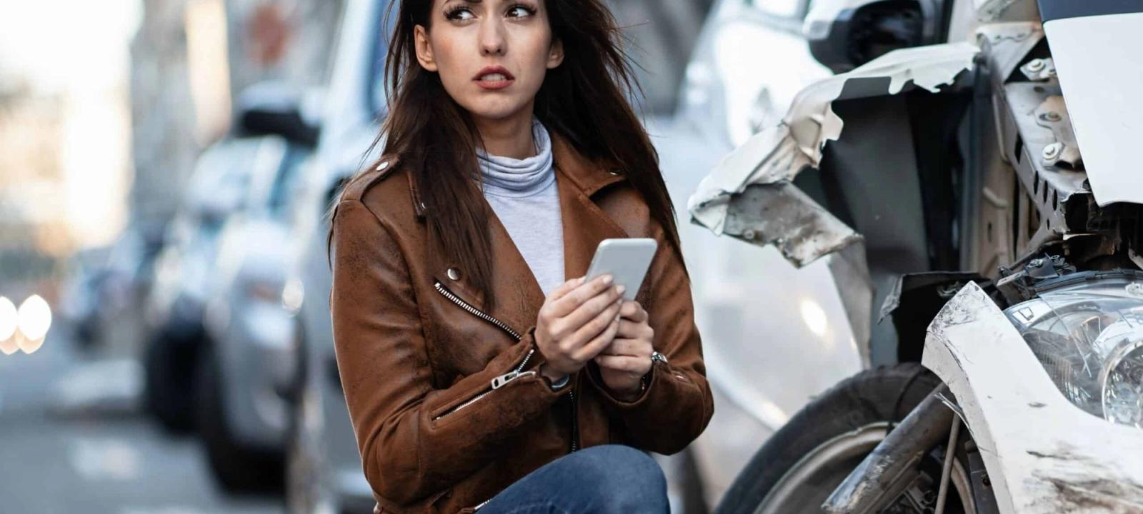 Distressed woman on phone after a car accident, emphasizing the need for case management support