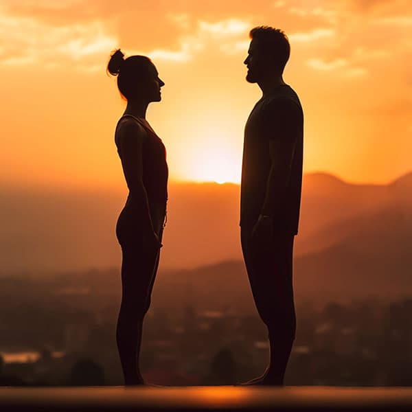 tantric couple facing each other at sunset