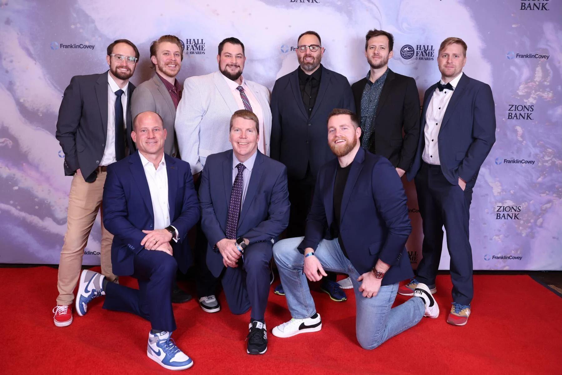 Team members smile on the red carpet