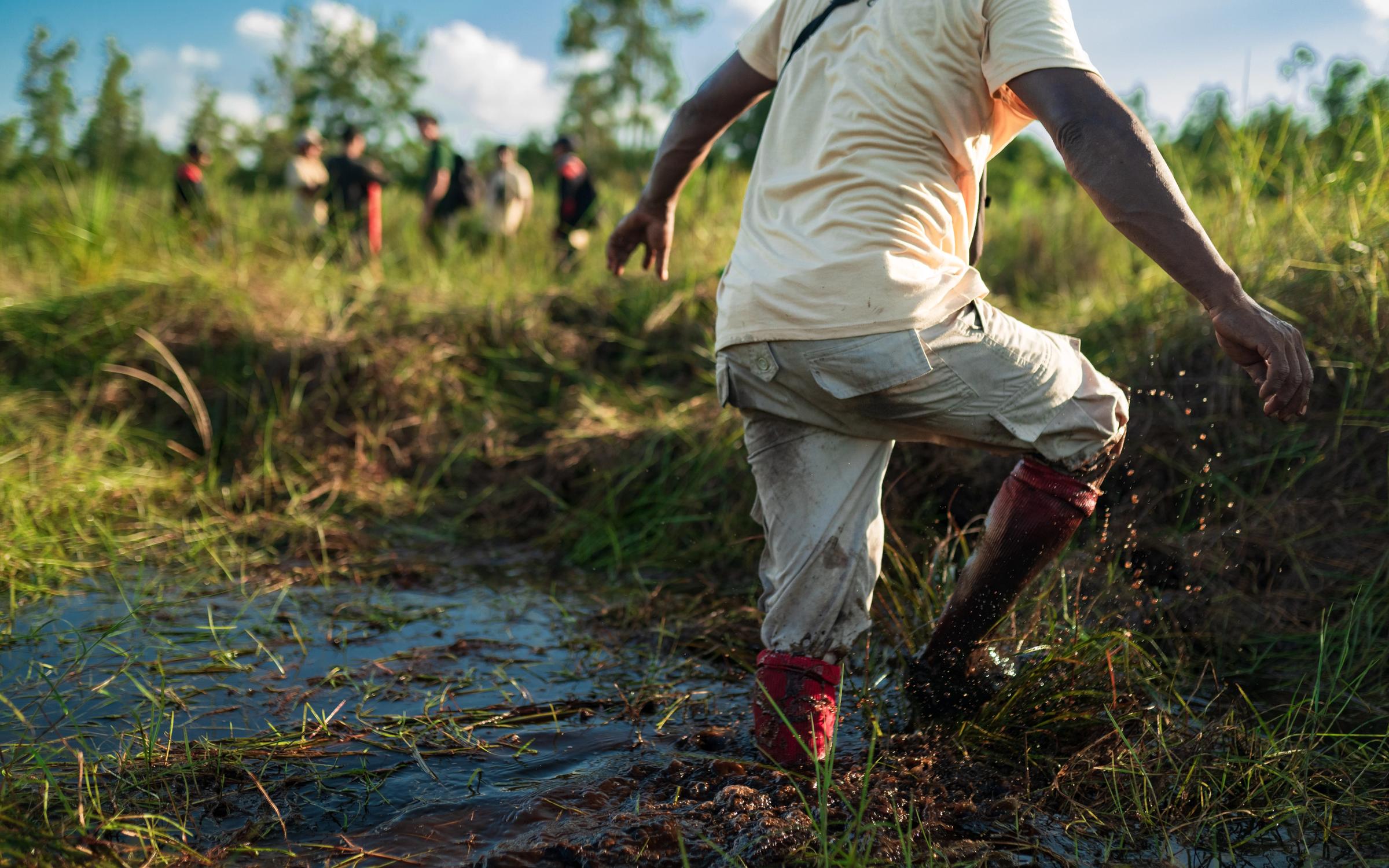 man stepping out of river in restoration site