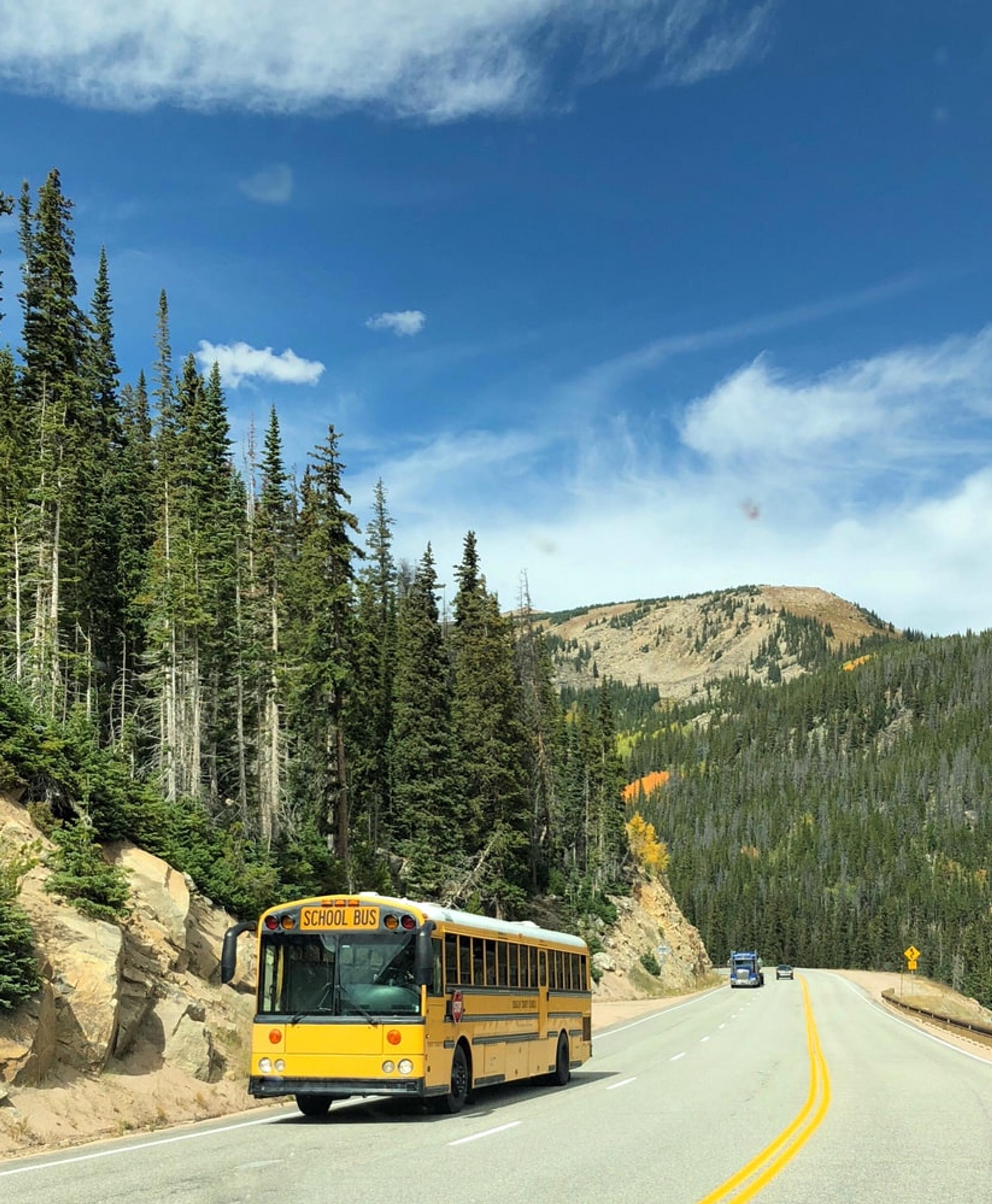 Yellow school bus on mountain road