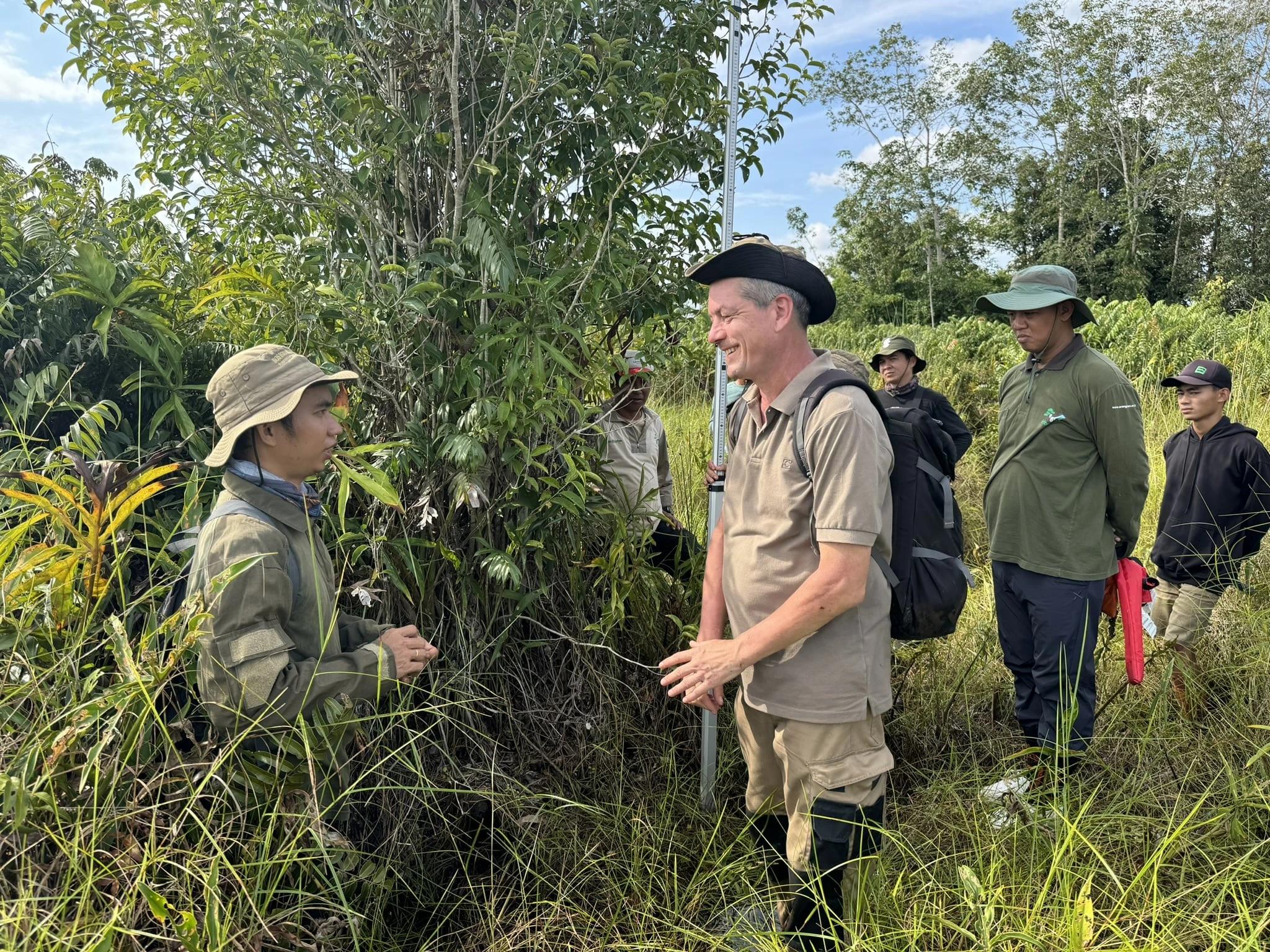 Indonesian locals in reforestation site with Land Life employee