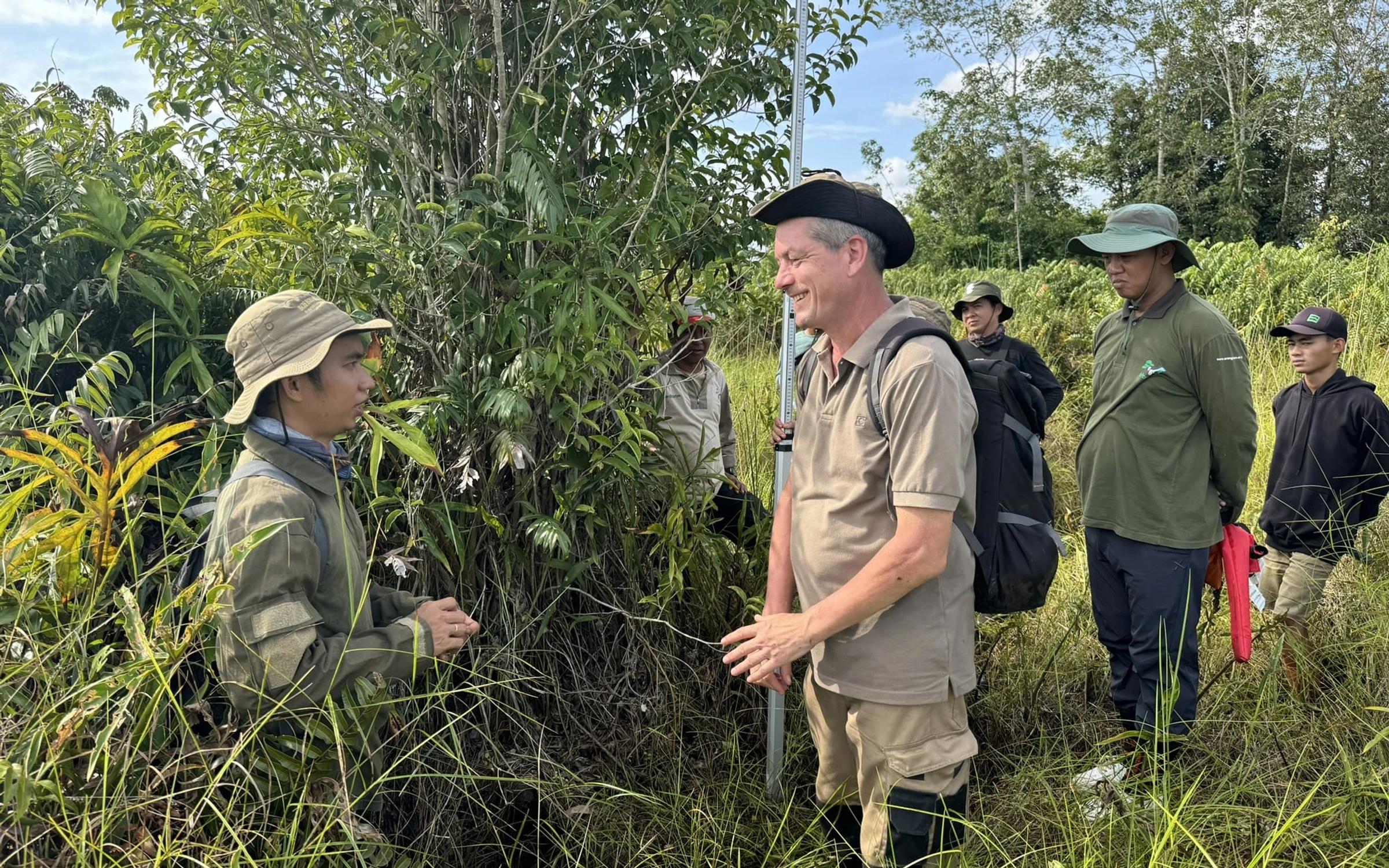 Indonesian locals in reforestation site with Land Life employee