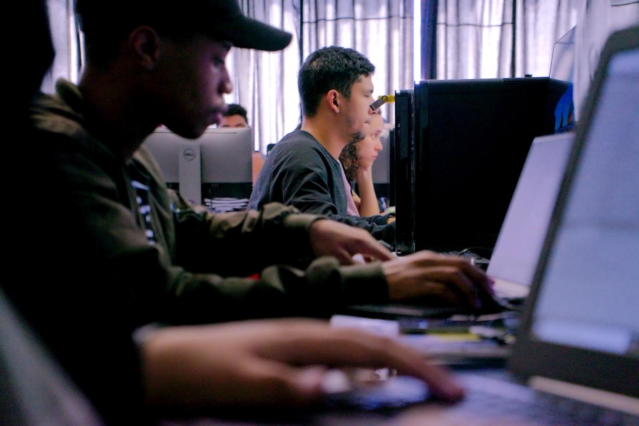 2 guys sitting in a classroom doing some stuff