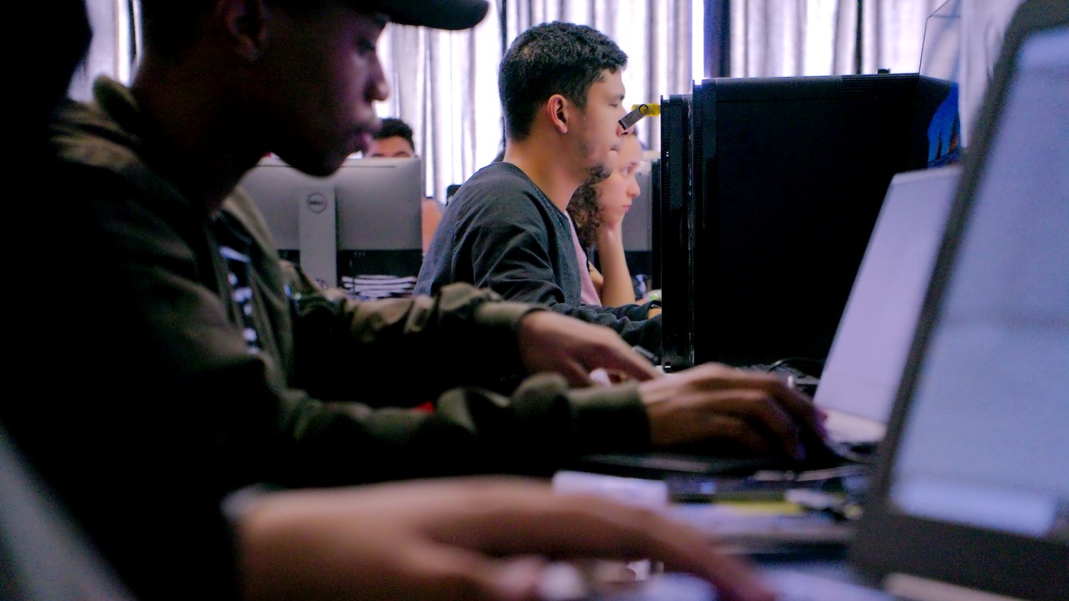 2 guys sitting in a classroom doing some stuff