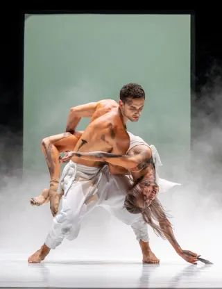 Twee mannelijke dansers waarvan één danser de andere draagt