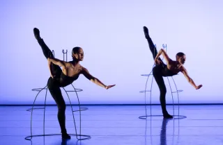 Twee dansers dansen in een ijzeren frame
