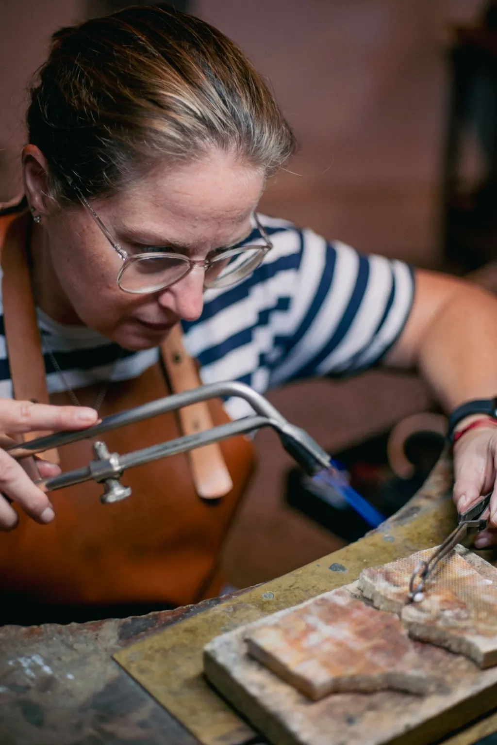 Een zilversmid aan het werk met een brander