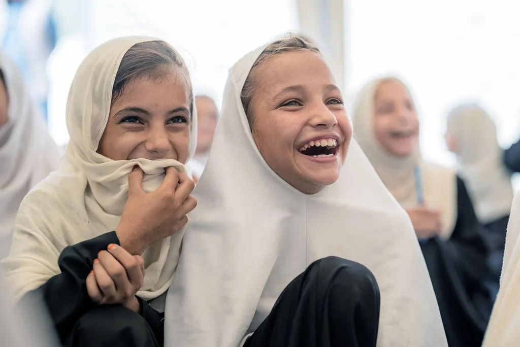 Twee meisjes met hoofddoek lachen