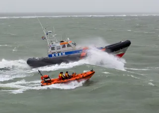 Een klein reddingsbootje naast een grote reddingsboot