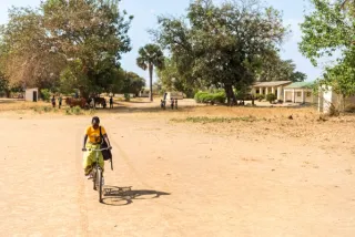 Foto van een Afrikaanse kraamhulp op de fiets