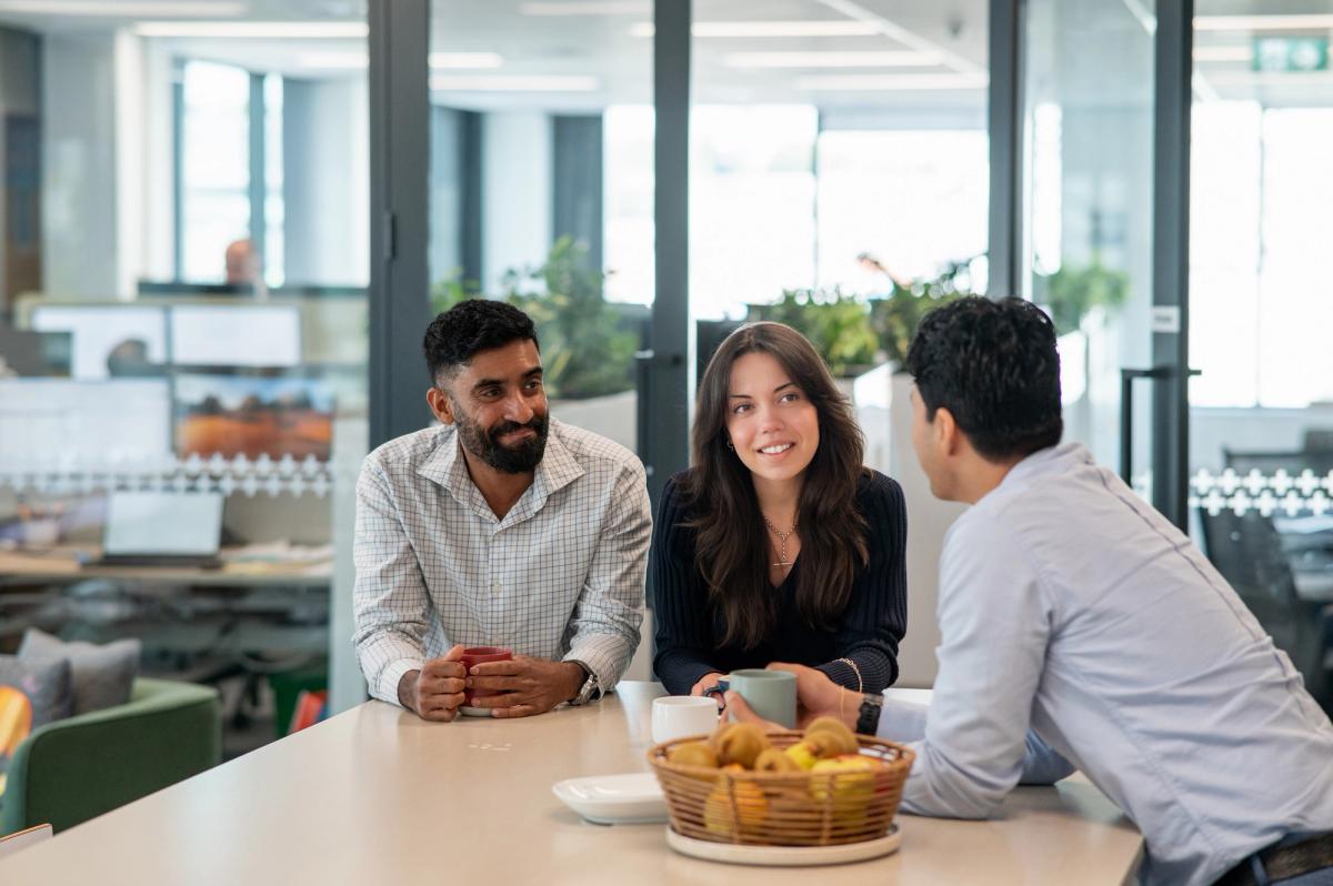 Group of people in discussion around a table, representing collaboration and purpose-led investment decisions.