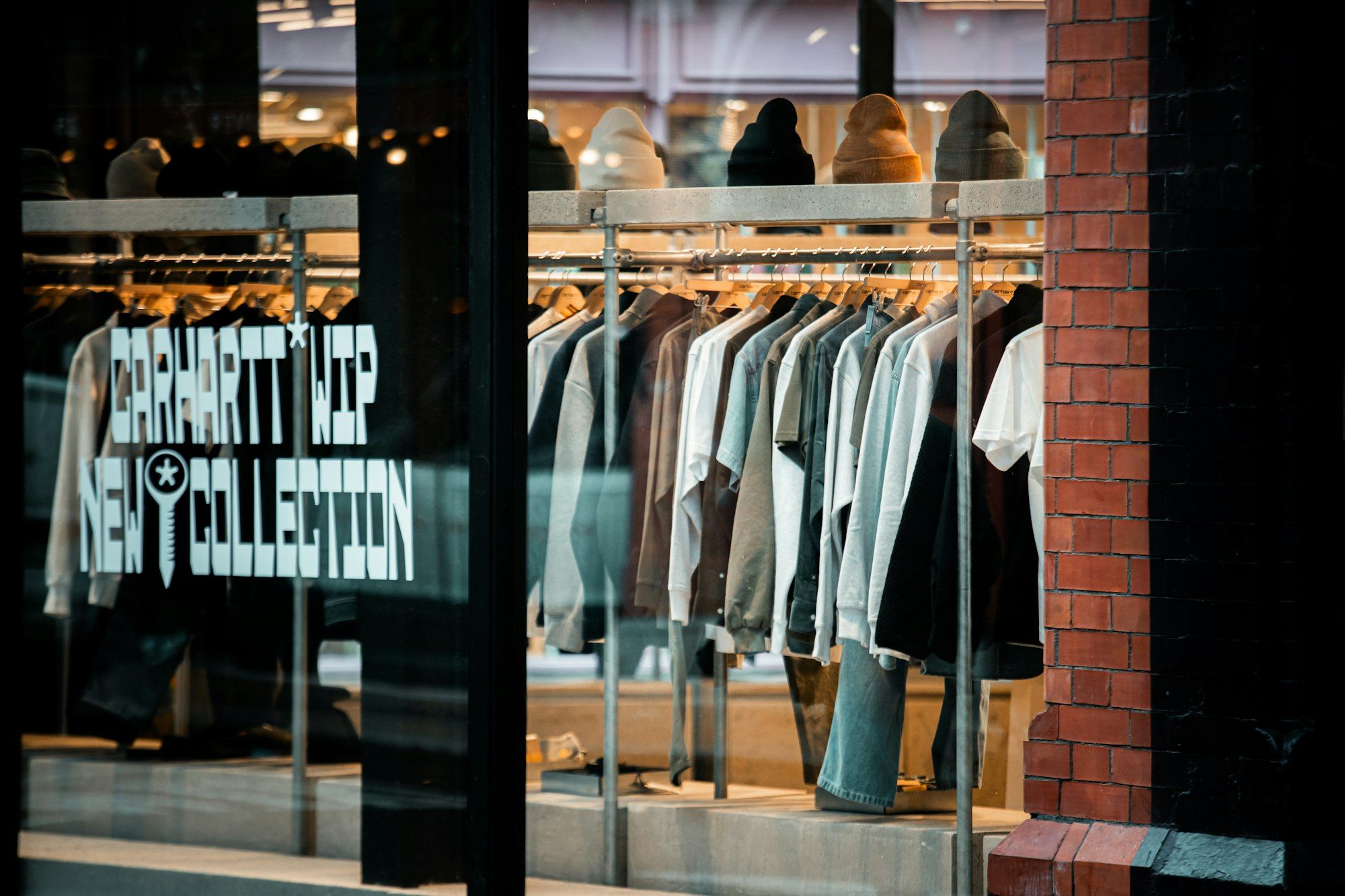 Clothes displayed on racks inside a store window