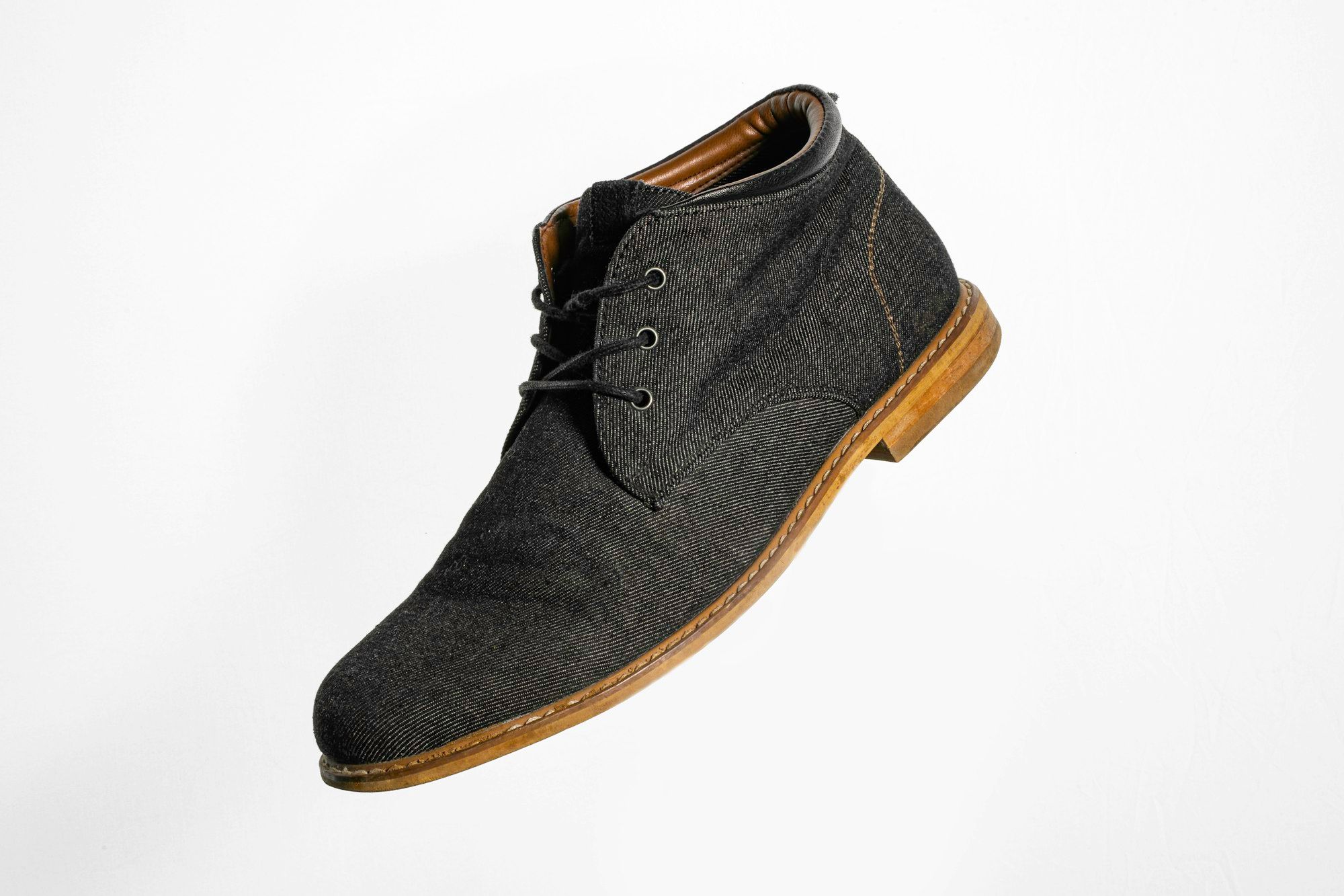 Gray and brown suede lace-up shoe on a plain background