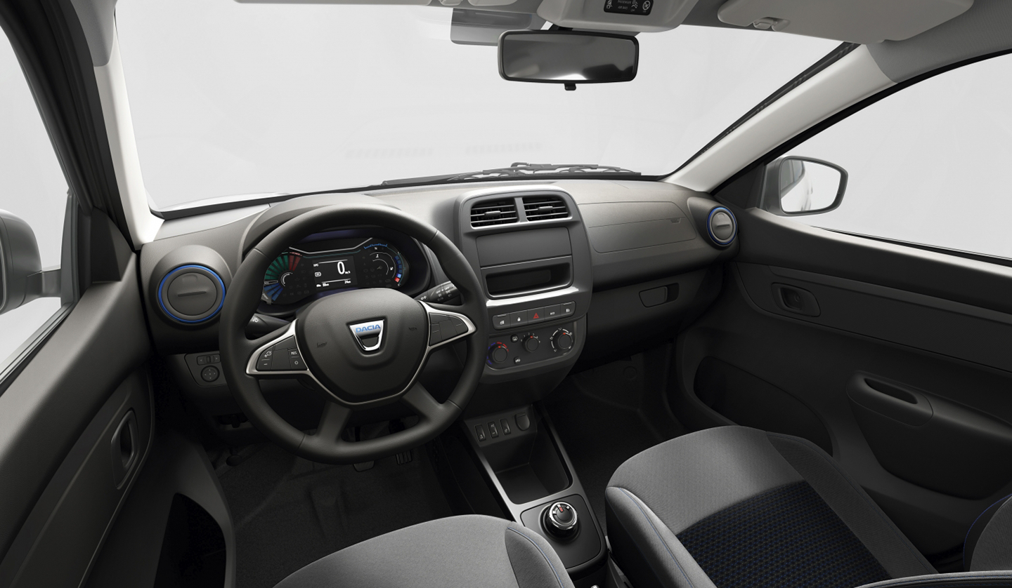 An interior shot of the Dacia Spring, showcasing the steering wheel and dashboard