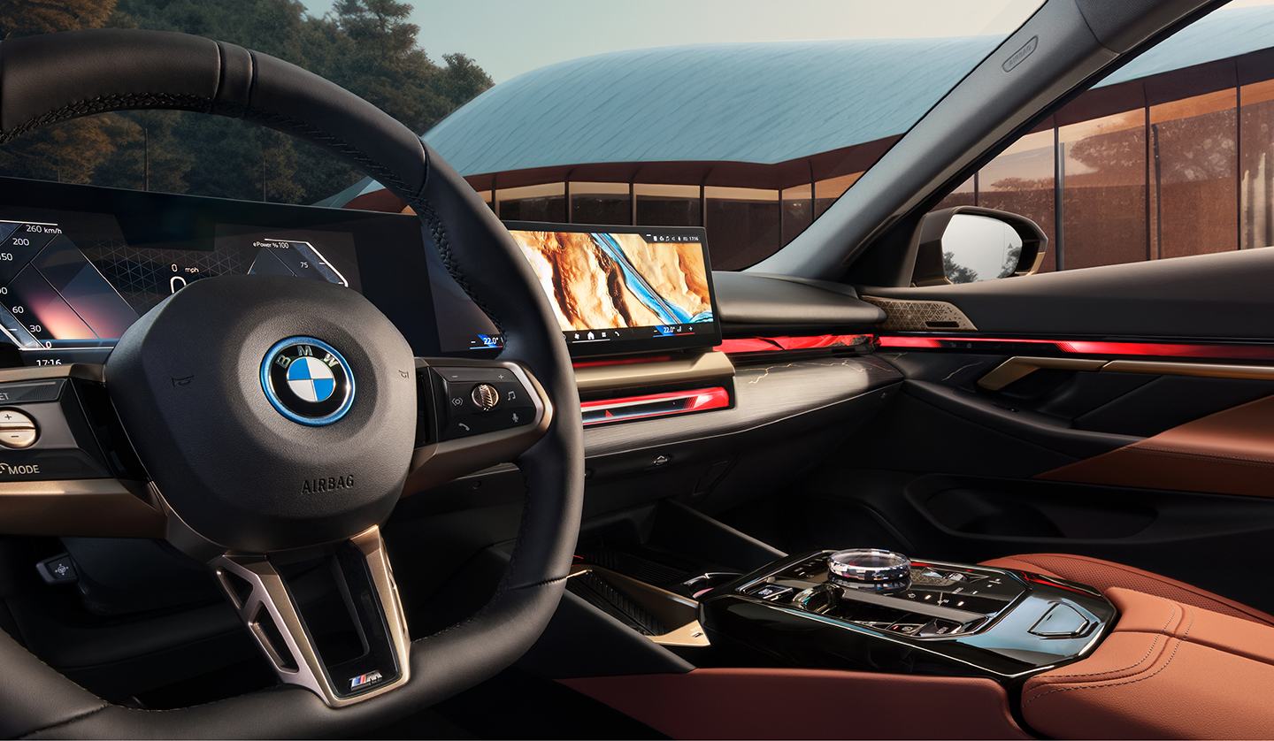 An interior shot of the BMW i5 showing the steering wheel and dashboard